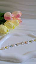 Bracelet forme fleur blanche et perles multicolores