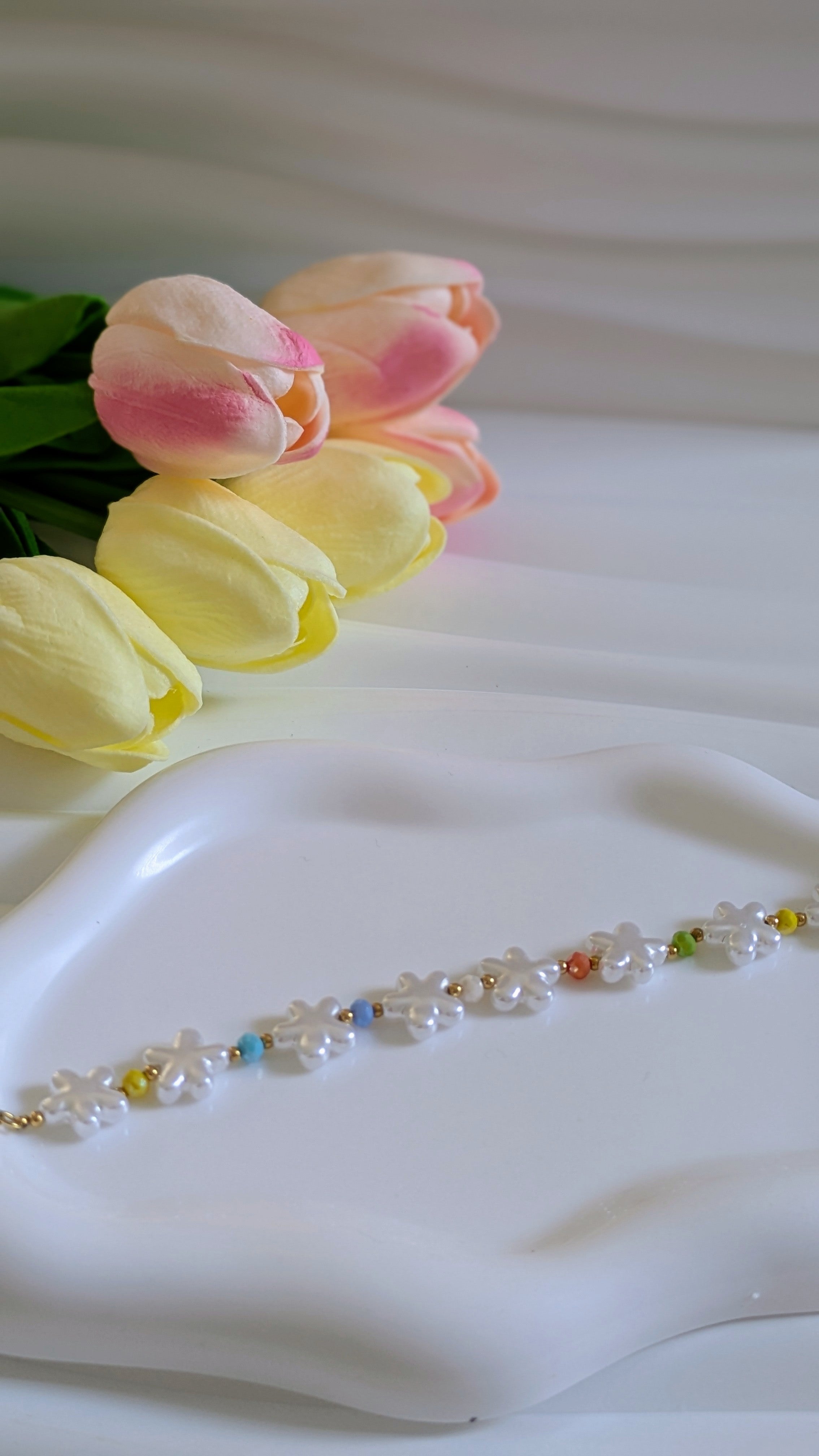 Bracelet forme fleur blanche et perles multicolores