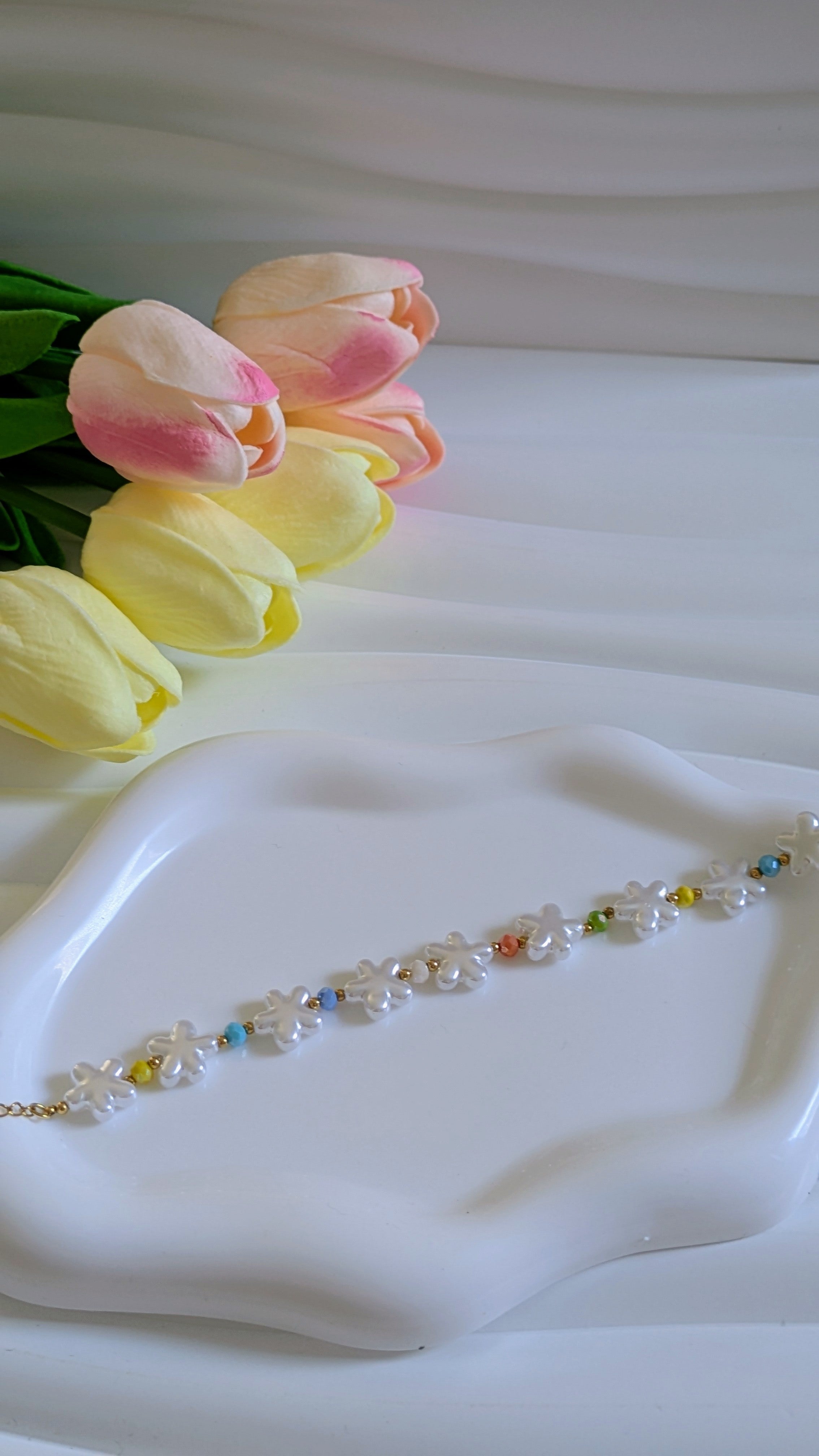 Bracelet forme fleur blanche et perles multicolores